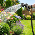 Expandable garden hose watering a lush garden (batch1 lifestyle)